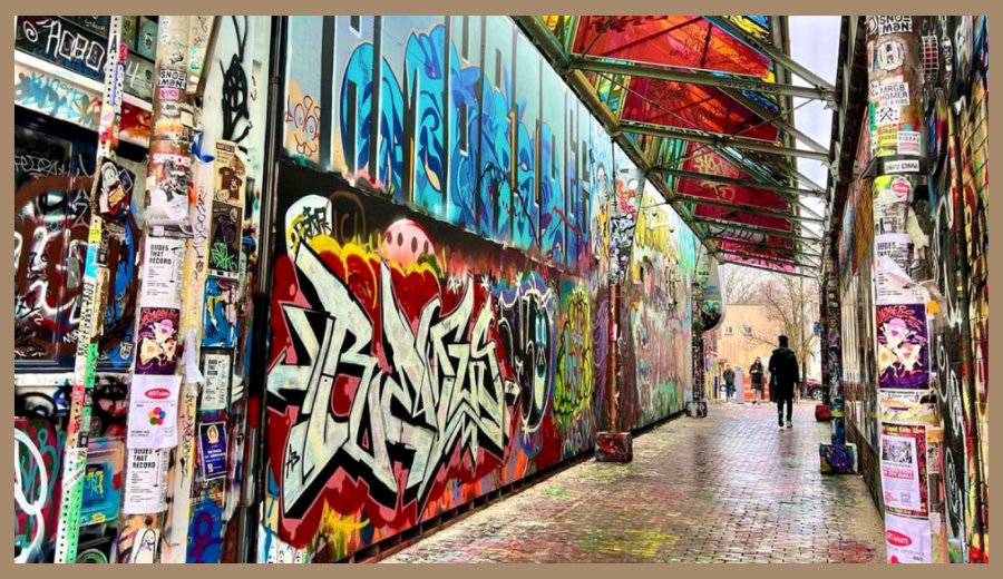 Colorful Toronto hidden gem street art in laneway with graffiti-covered walls and posters