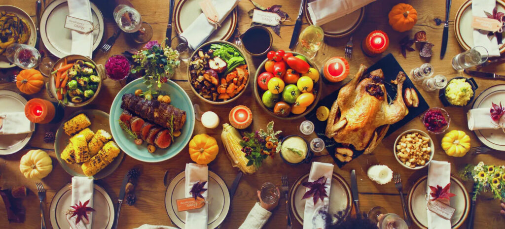Happy family celebrate Thanksgiving day, sitting at table with roasted turkey and holiday